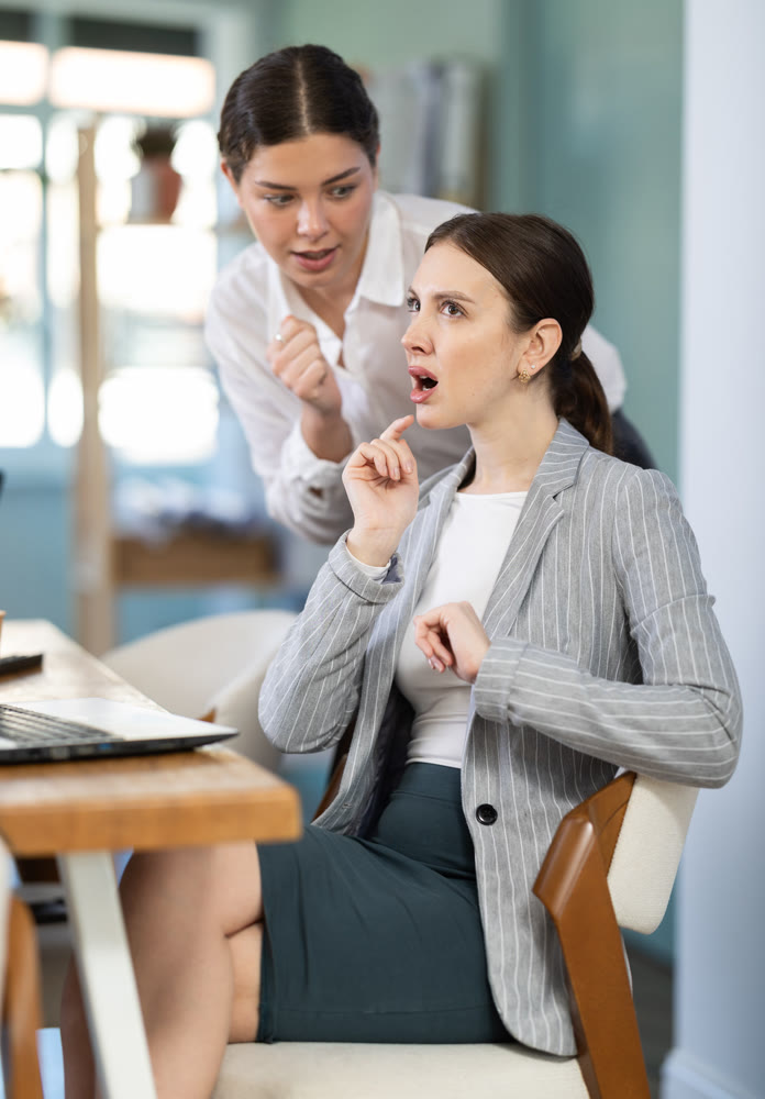 women gossip about colleagues in the office