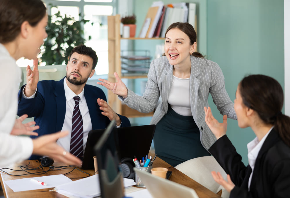 Group of men and women arguing loudly in office
