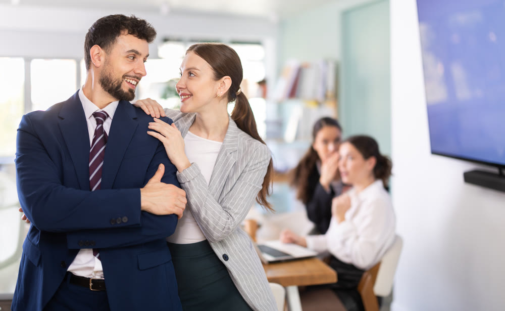 Coquettish female employee flirting with male coworker in office