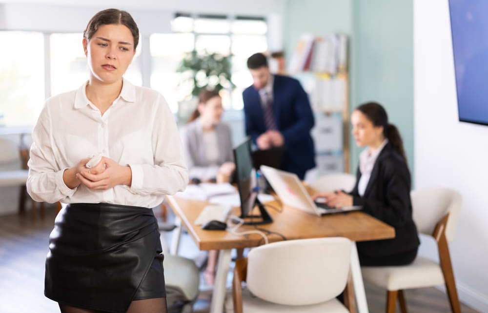 Upset woman stands in the middle of the office