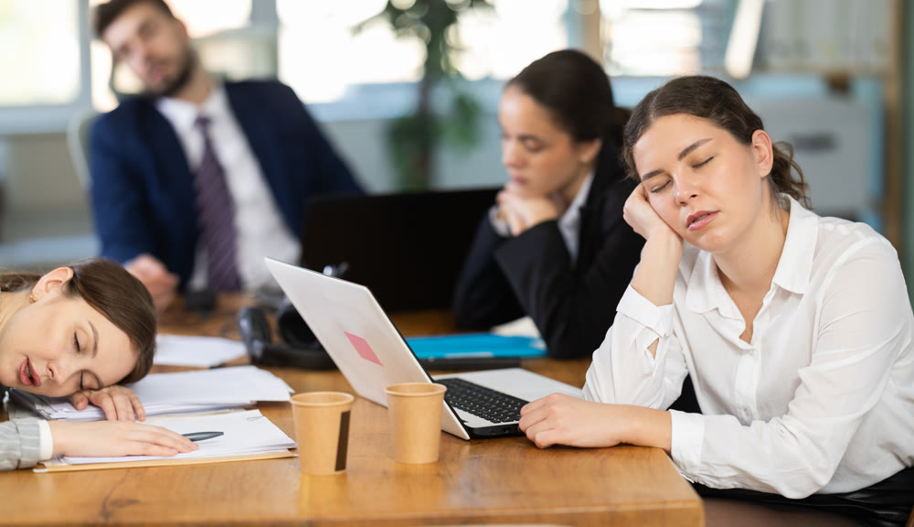 Group of tired colleagues working on laptop