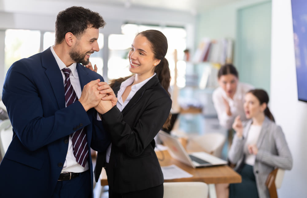 Man and woman holding hands in office