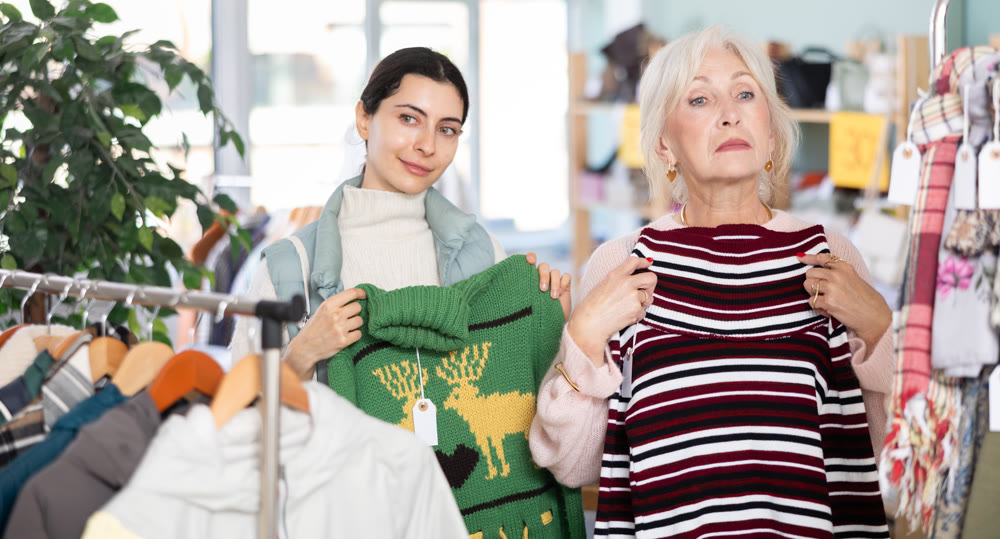 Regular customer mature woman and Armenian girl choose color and style of sweater