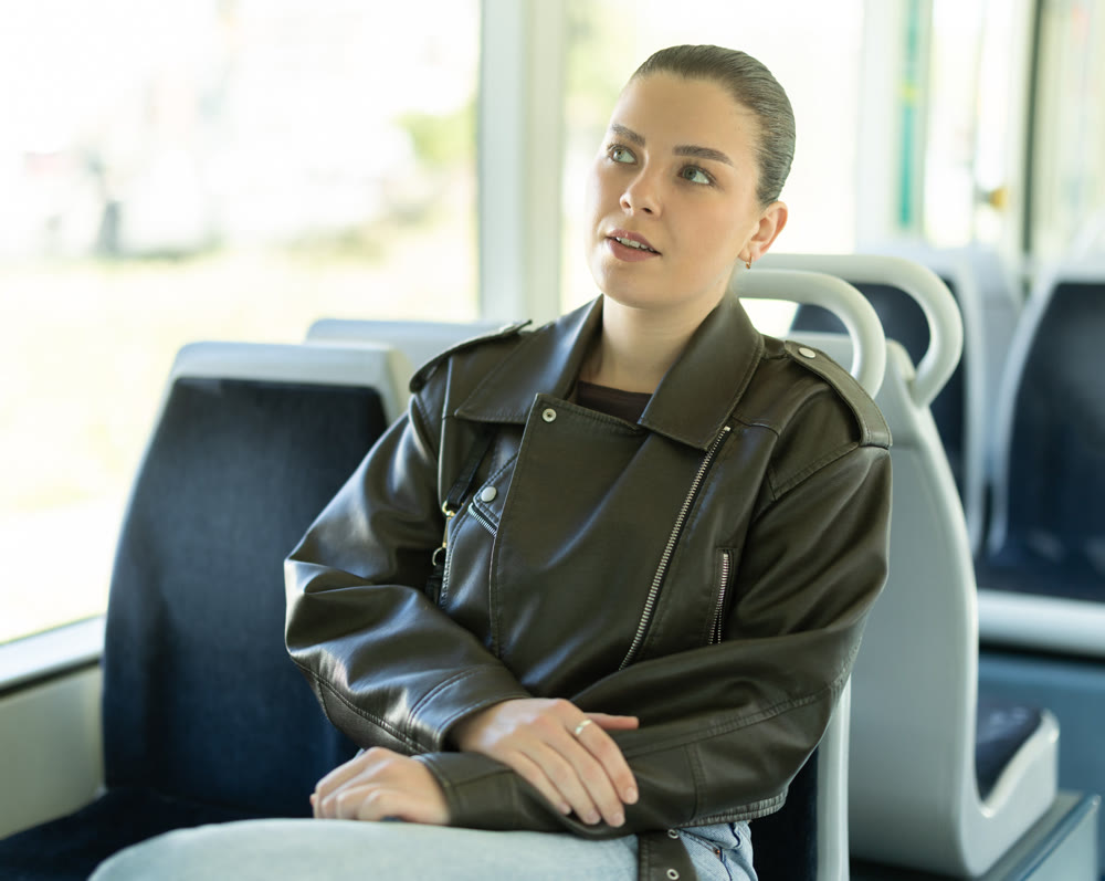 Young woman sitting while riding tram