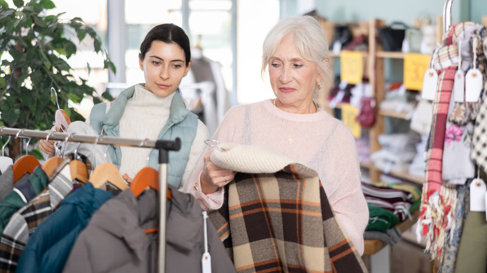 Elderly and young woman choosing coat or down jacket
