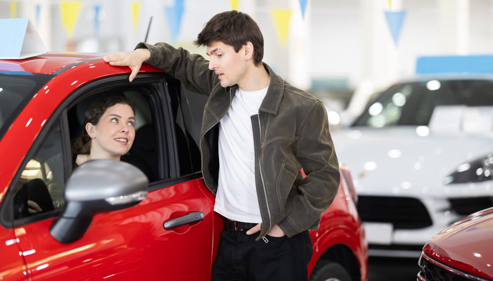 Young couple in a car dealership chooses a car