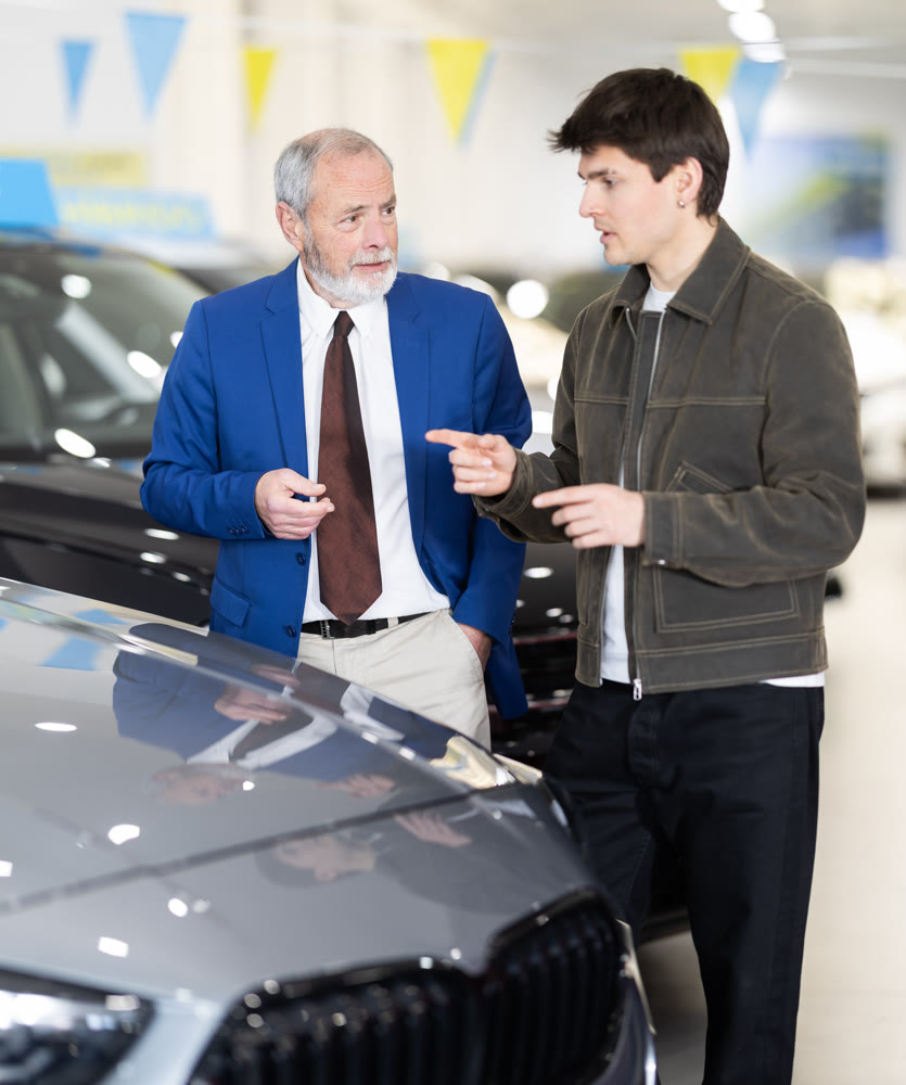 Elderly seller shows the car to a guy