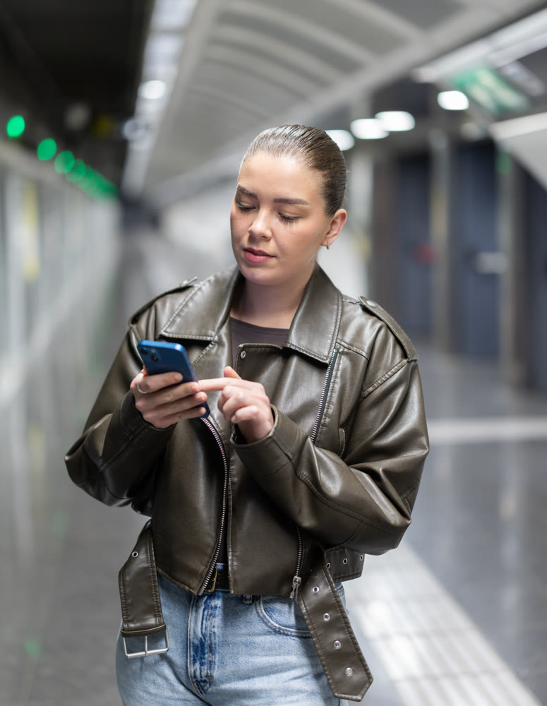 Girl standing at subway station. Woman looks at the metro map and checks where to transfer between stations