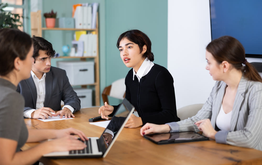 Business team discusses a project at a desk