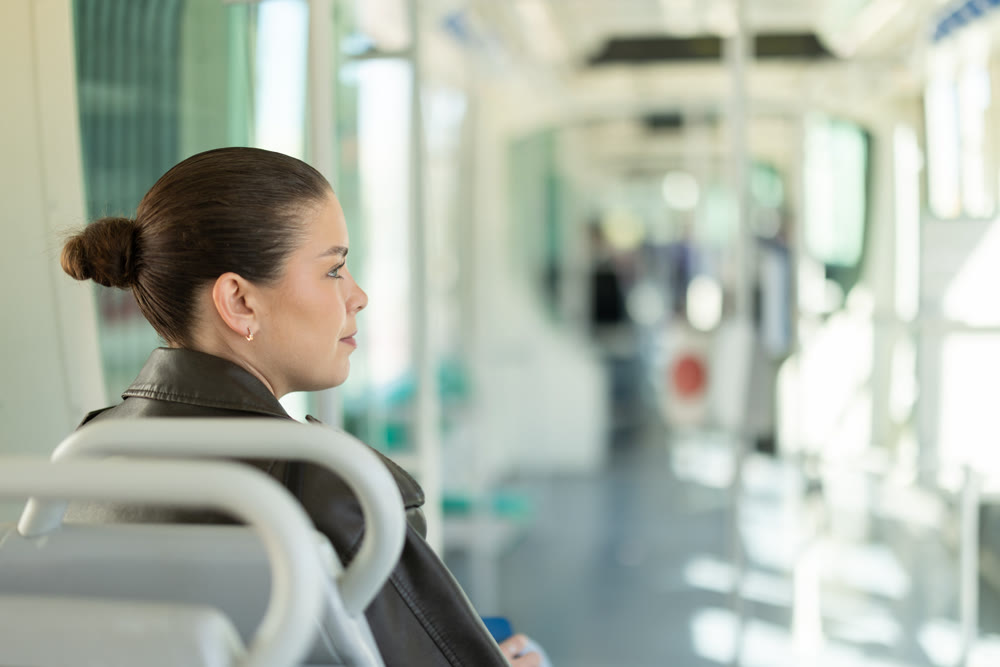 Portrait of woman in black leather jacket on tram. Traveling by public transport