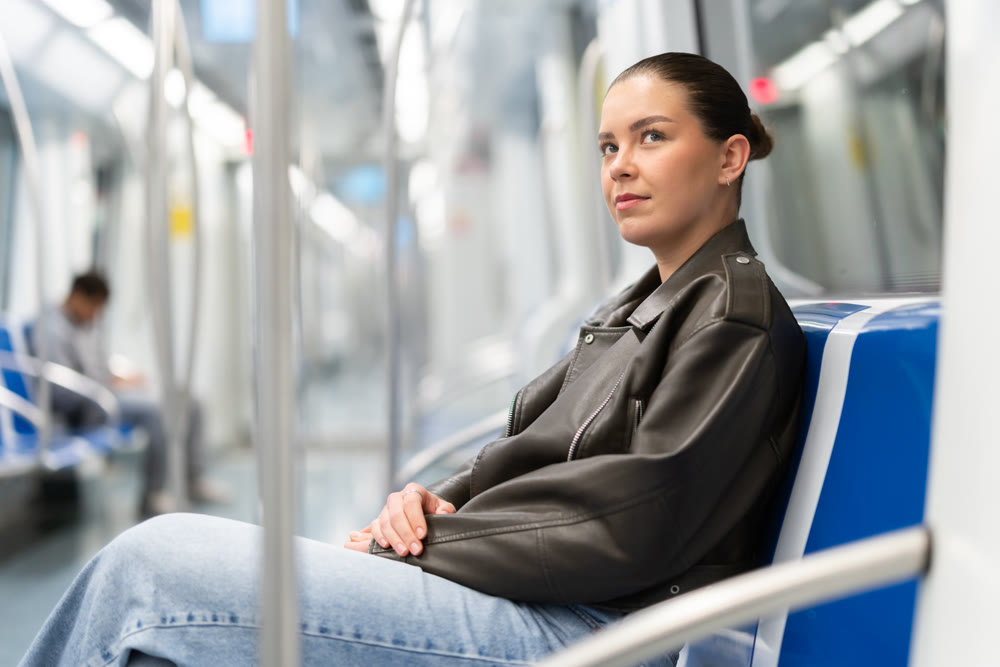 Portrait of woman in black jacket on a subway train. Traveling by public transport