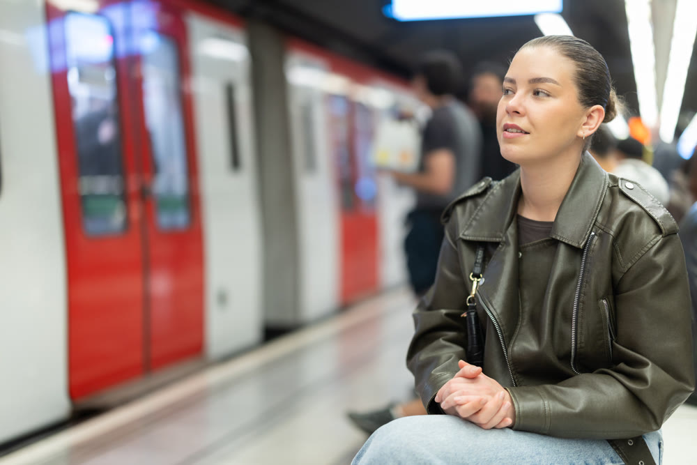 Young woman sitting at subway station