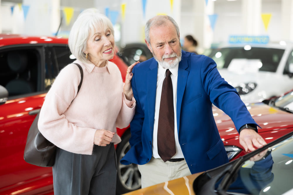 Elderly couple chooses new car together at car dealership