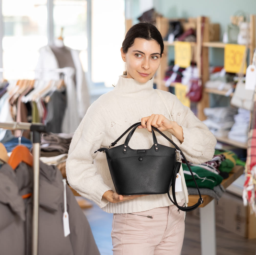 Young women choosing handbag in store