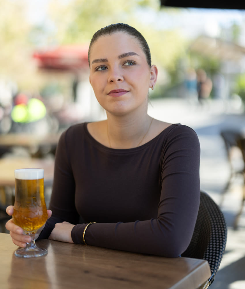 Young woman drinking beer in cafe