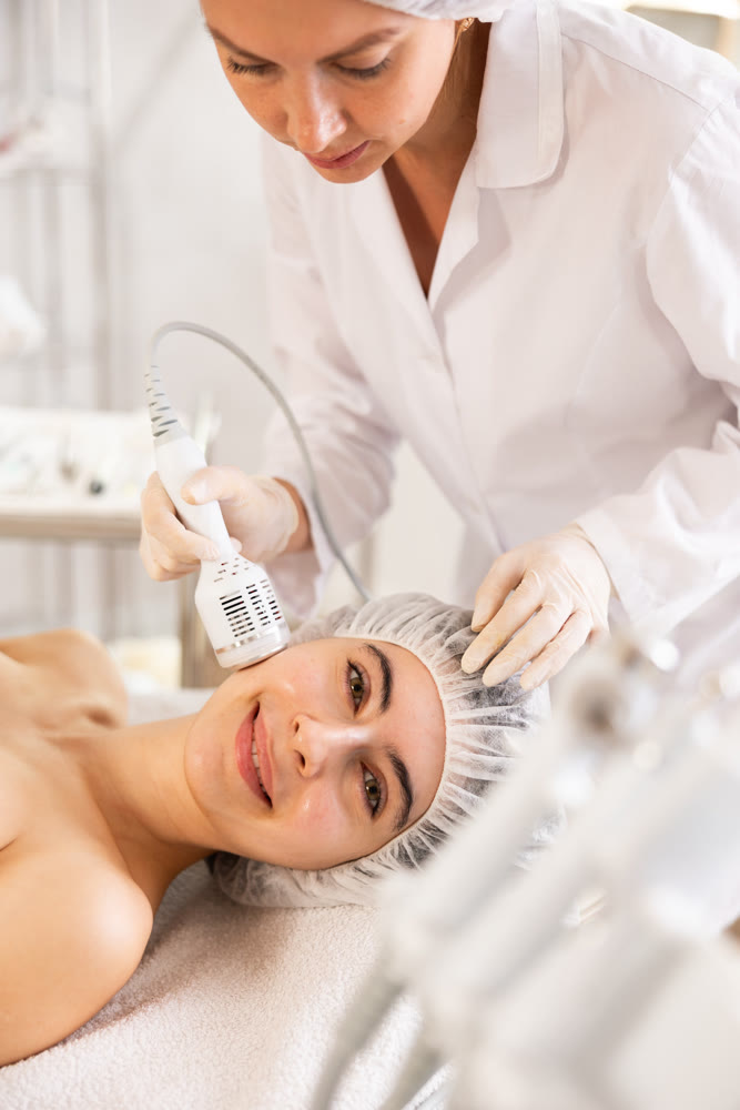 Female patient experiencing facial cryotherapy procedure in cosmetic clinic.