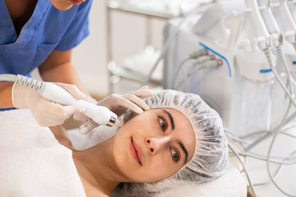 Woman undergoing facial procedure with application of atomized nutrients