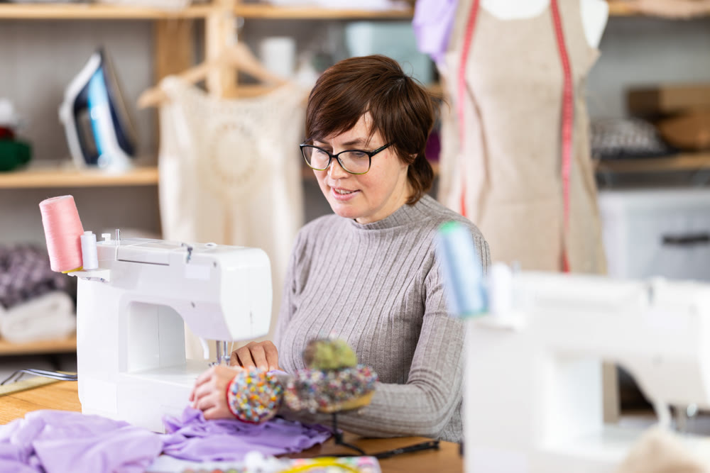 Woman tailor sews clothes in sewing machine