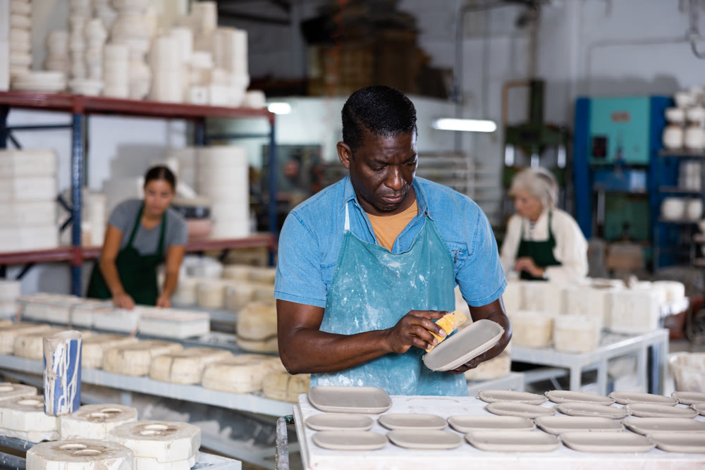 Man potter polishing new crafted plates