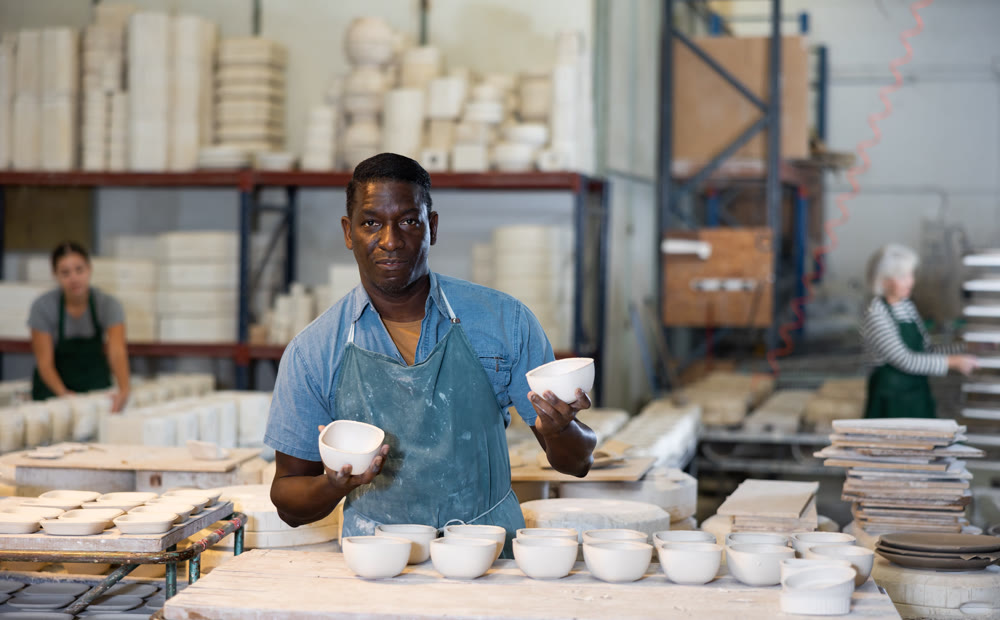 Man ceramist working in pottery workshop