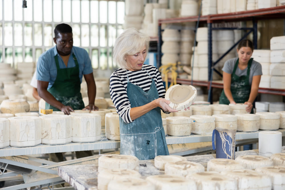 Positive mature woman potter with form for new ware