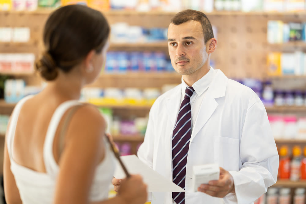Girl client with prescription should contact man pharmacist for help, takes box remedy