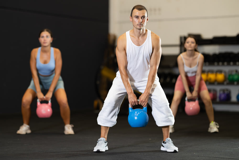 Young man training with kettlebell in gym