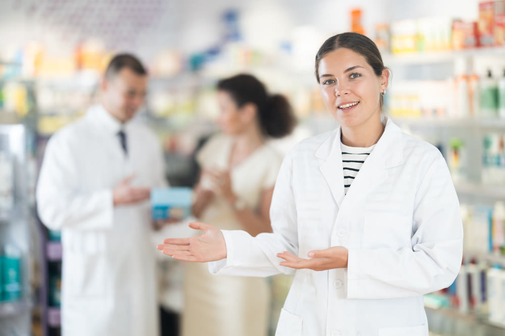 Female pharmacist in medical uniform posing while working in pharmacy