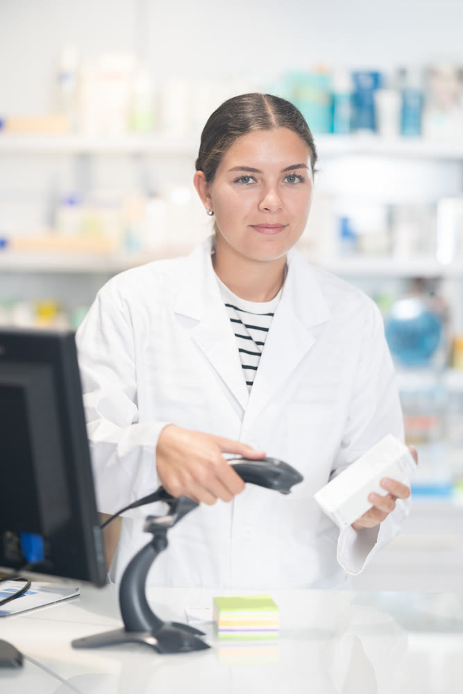 Girl pharmacist scans qr code of product at checkout for sale