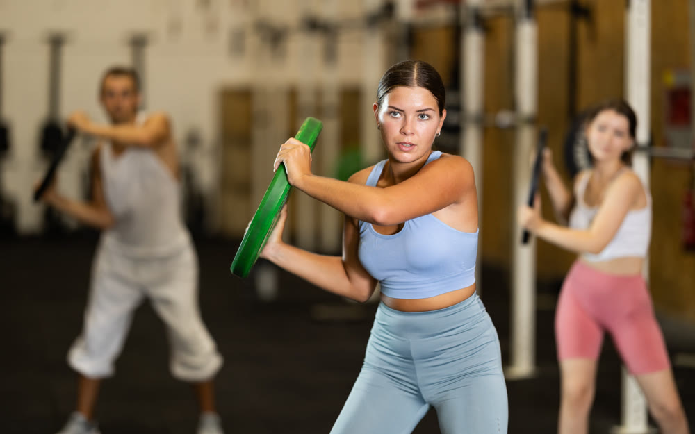Young woman training with weight plate