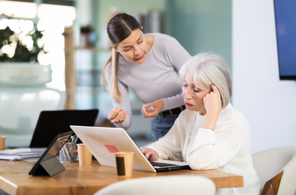 Female boss yells at senior woman employee, pensioner work at computer
