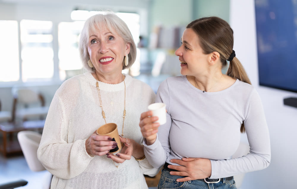 Elderly and adult women laughing and talking during coffee break