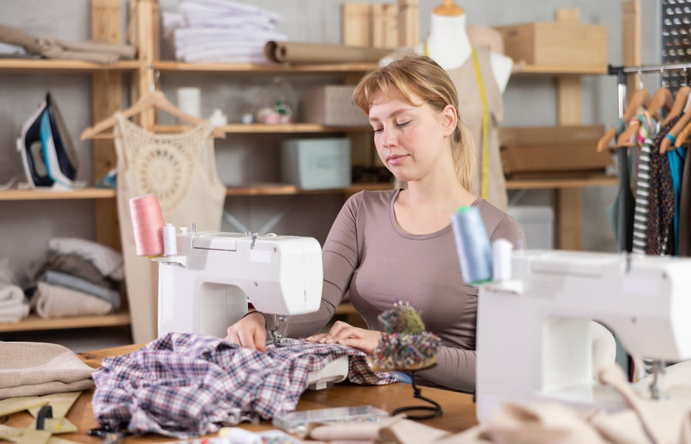Woman tailor working at sewing machine