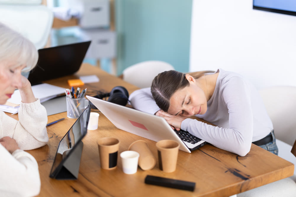 Tired elderly and adult female colleagues fall asleep while working