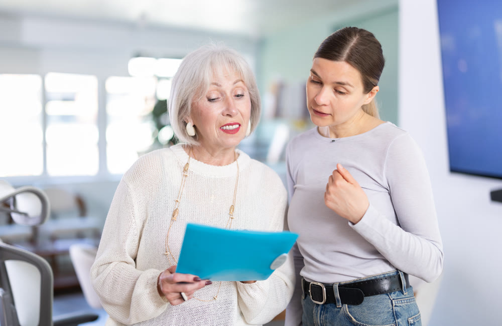 Woman shows elderly colleague documents