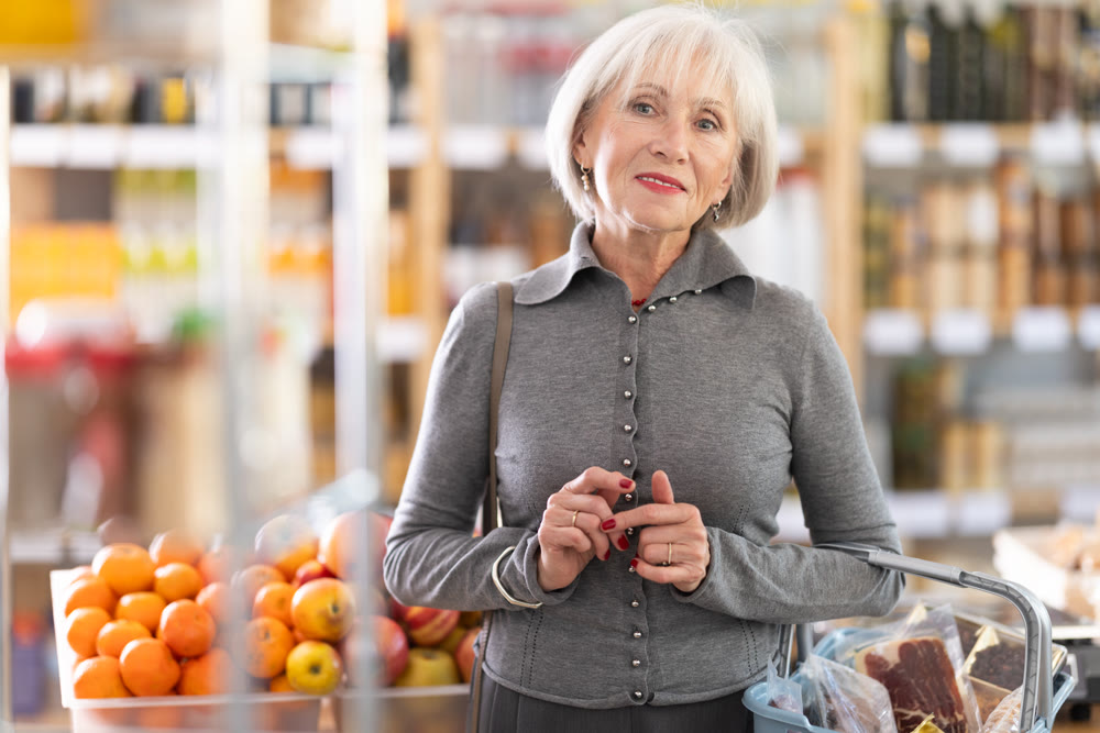 Elderly woman choosing food in grocery store