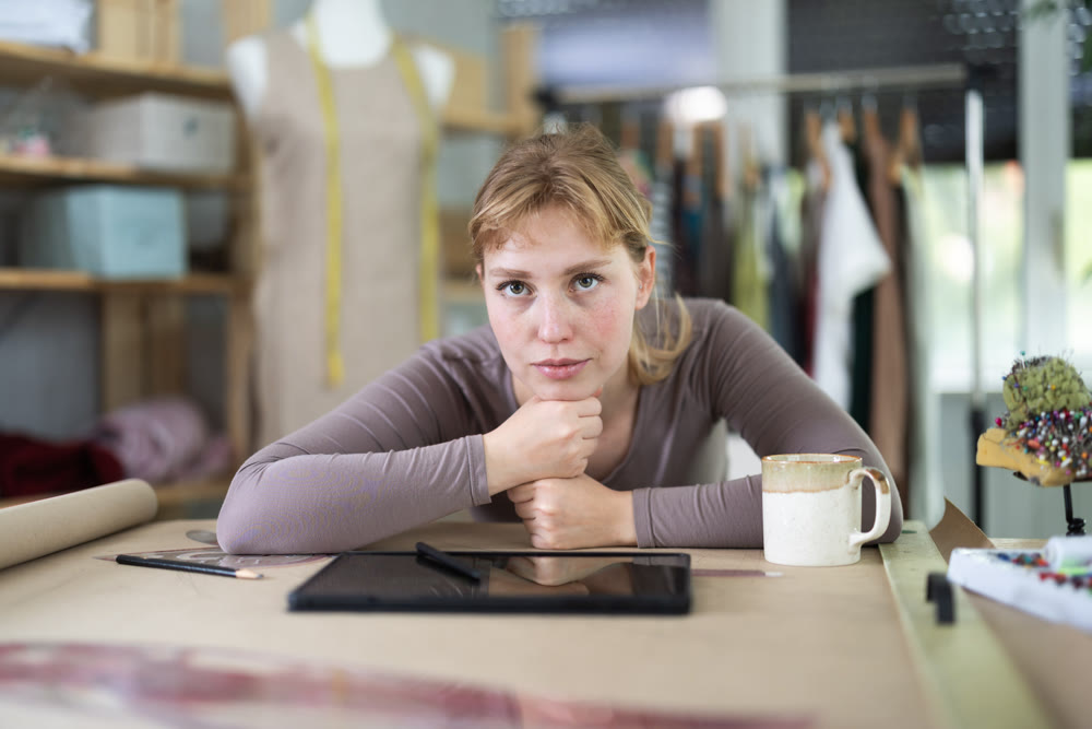 Tired dressmaker worker at table