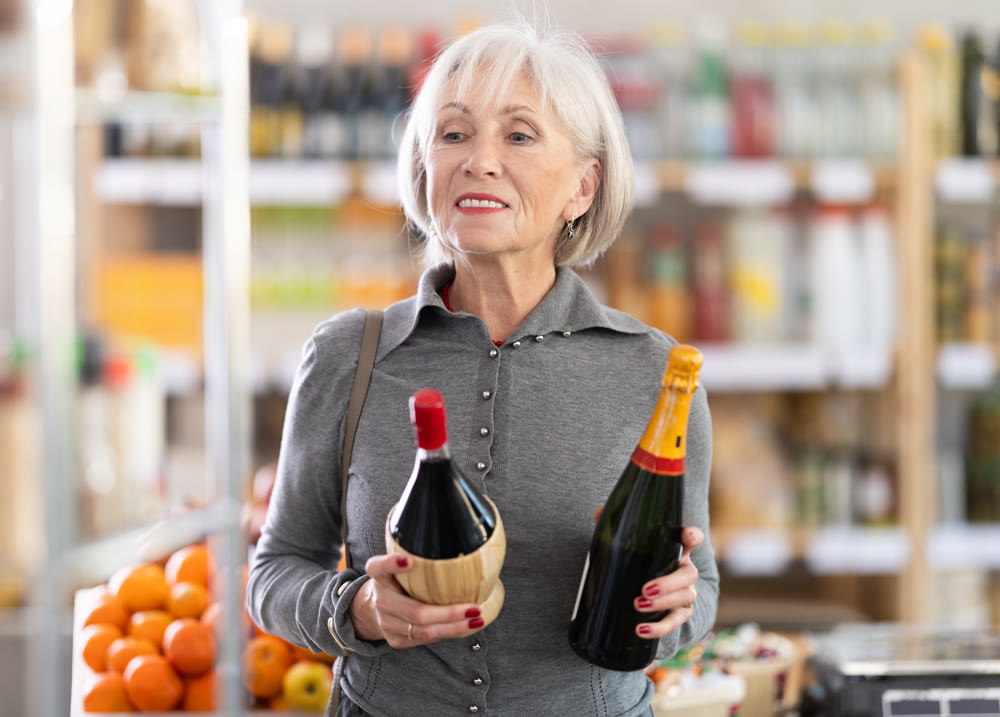 Elderly woman chooses wine or champagne