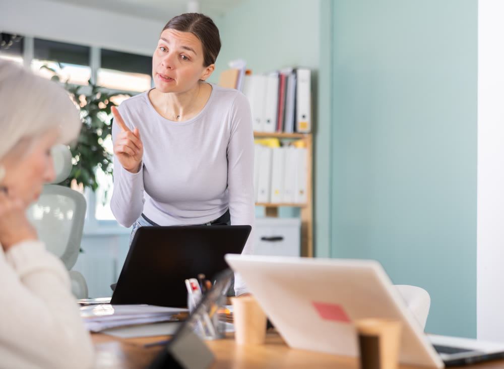 Female boss scolds an mature subordinate for errors in documents