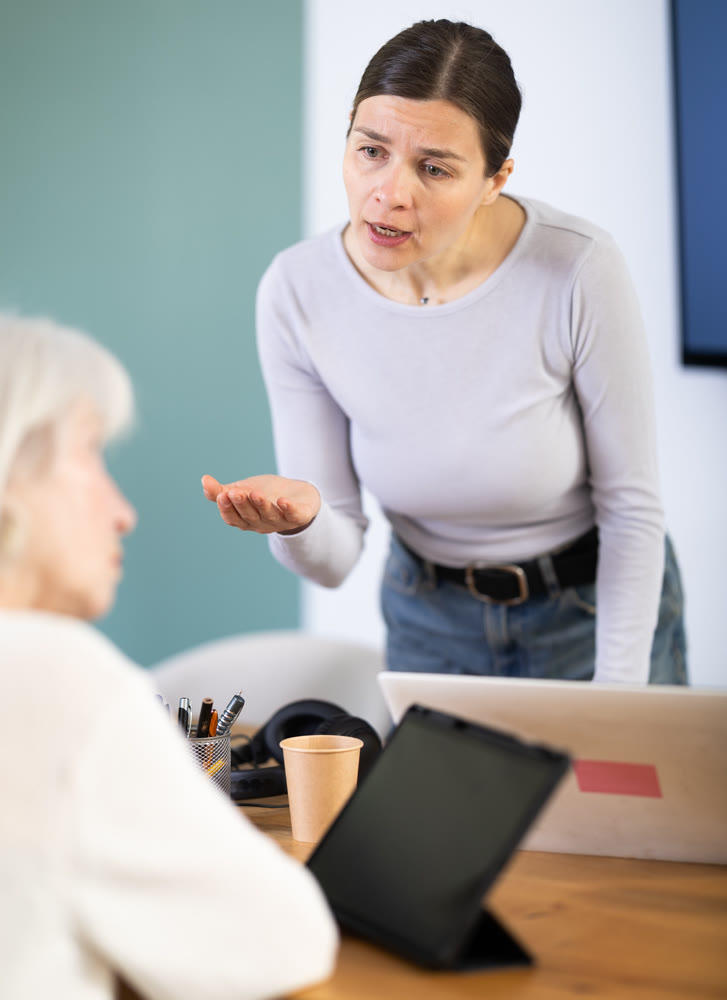 Female boss scolds an mature subordinate for errors in documents