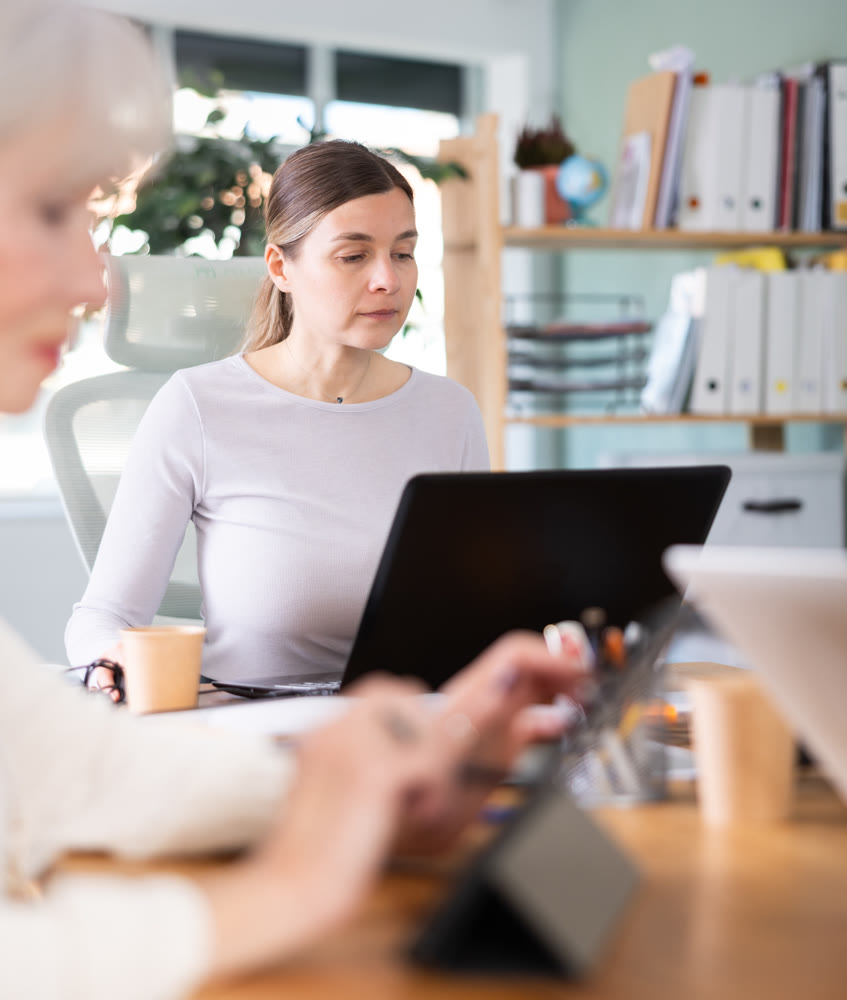 Elderly and adult women working in office