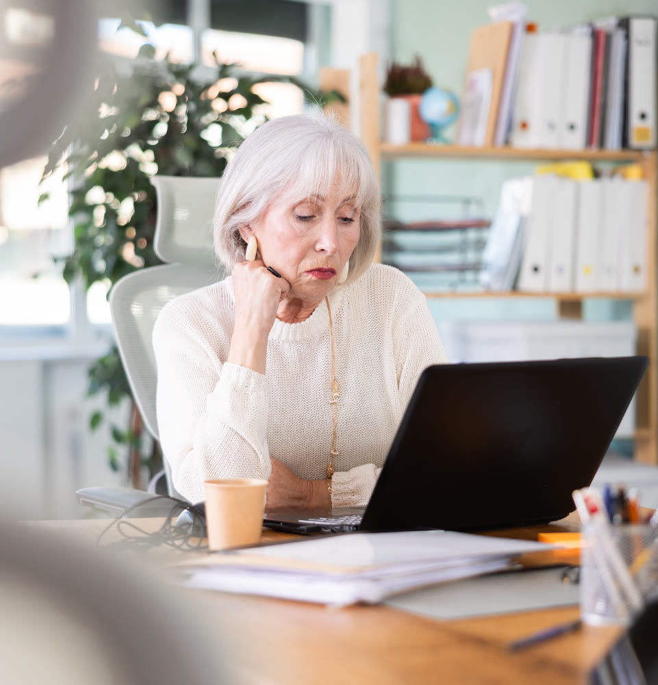 Elderly businesswoman, senior manager, work on laptop in modern company office