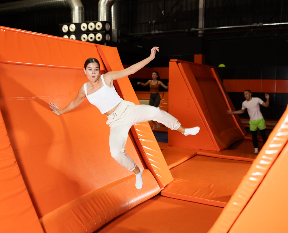 Portrait of sporty girl jumping on trampolines in her free time in gaming club