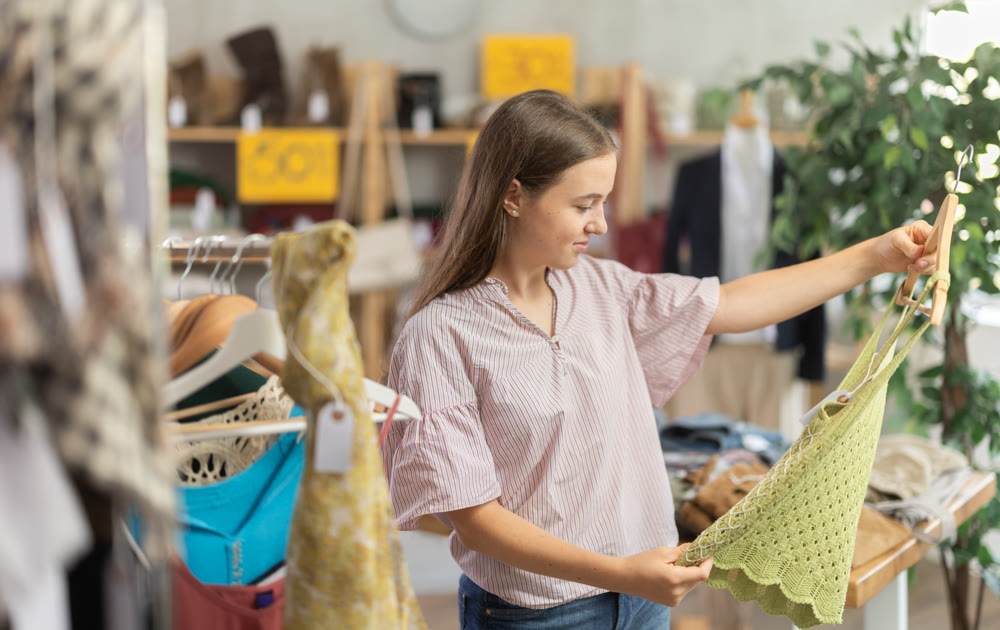 Teenage girl choosing top in clothing store