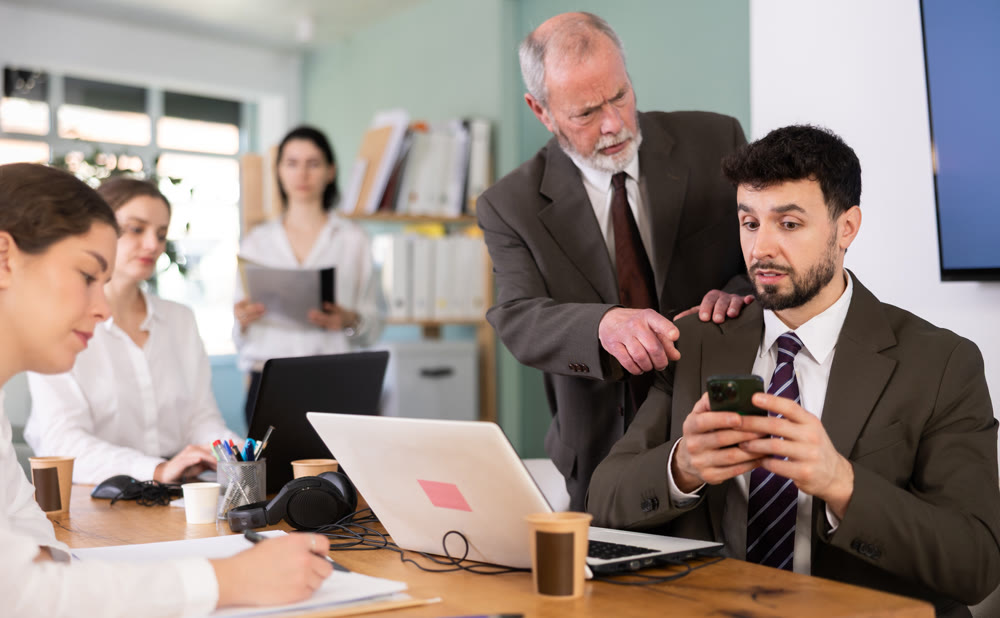 Mature man boss found man subordinate idling and scrolling phone, mentor shouts at subordinate.
