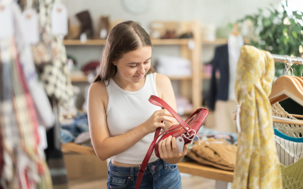Teenage girl choosing handbag in store