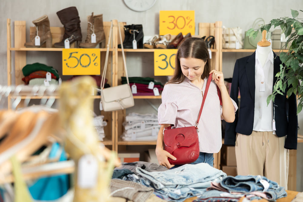 Teenage girl choosing handbag in store