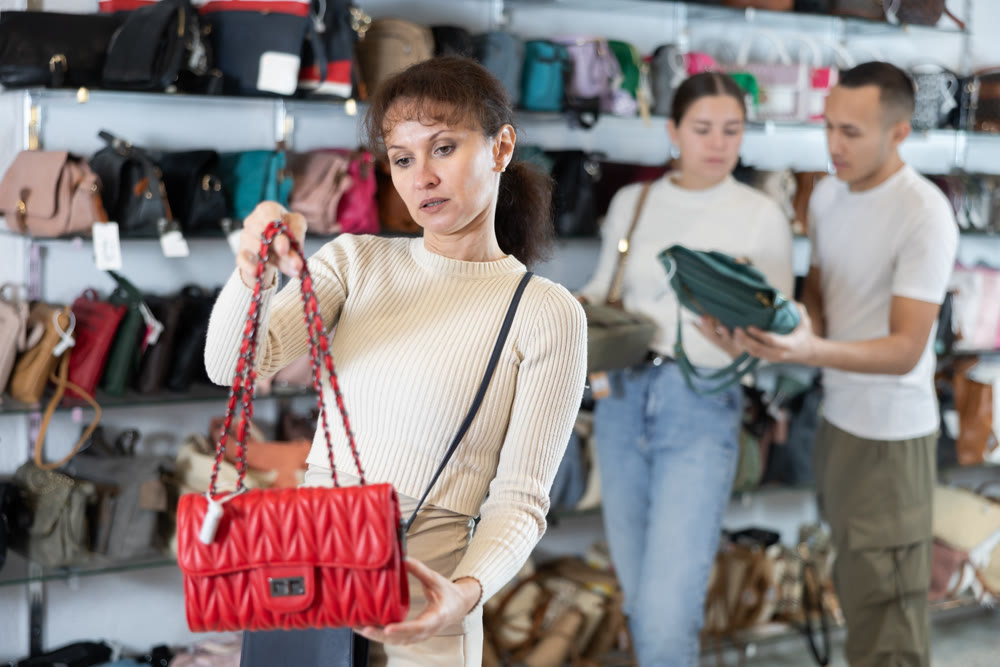 Adult woman choosing handbag in store