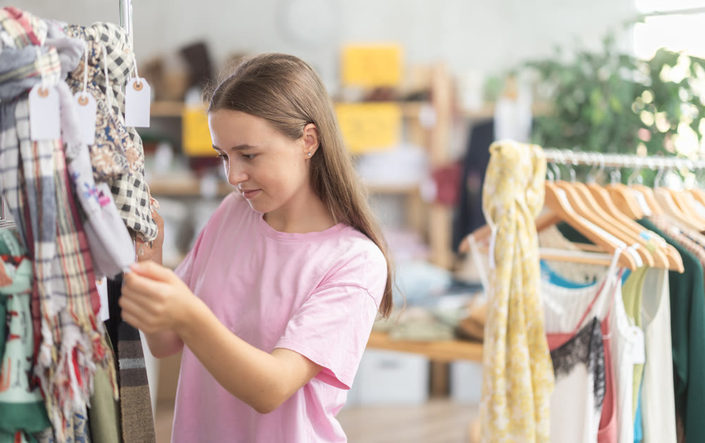Teen reading labels on scarves in store
