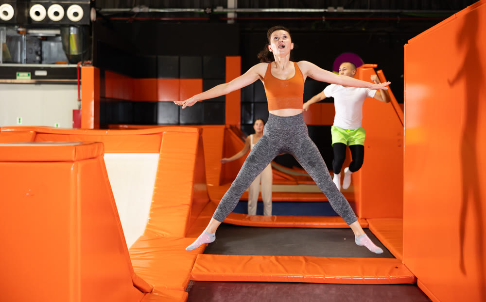 Middle-aged woman practice jumping on trampolines at trampoline center